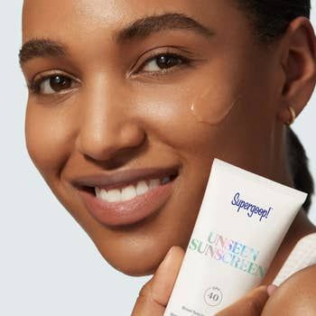 model showing a swatch of transparent sunscreen on her cheek