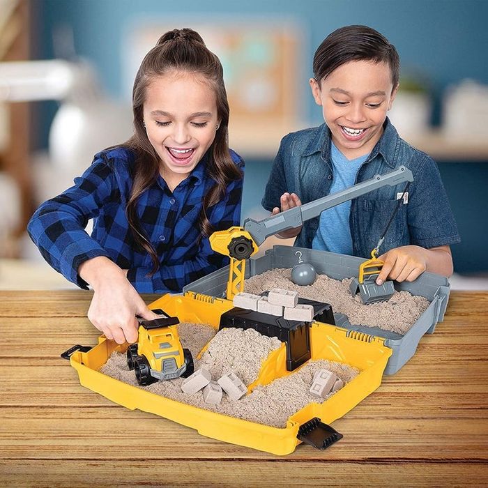 Two kids playing with the kinetic sand folding sandbox playset