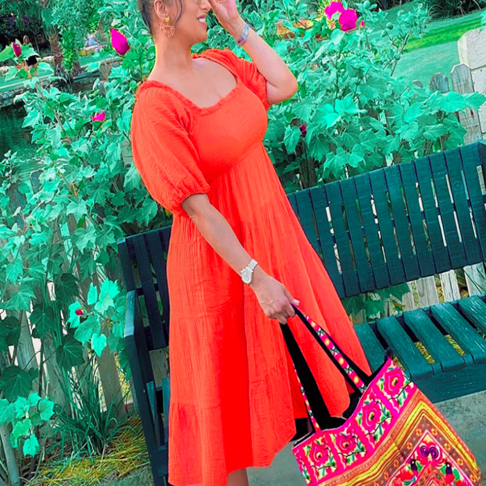 A customer review photo of them modeling the dress in orange