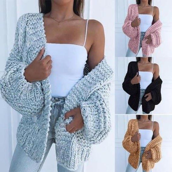 A model rocking the chunky knit sweater in a mix of gray, brown, black, and pink hues for a unique and cozy style.