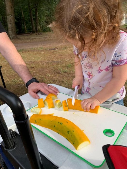 A reviewer’s child happily slicing a squash with one of the knives