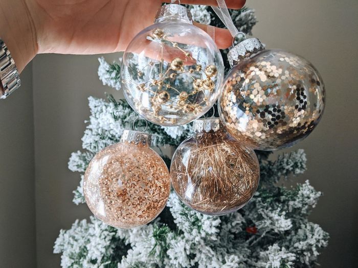 Reviewer photo showcasing four golden ball ornaments placed in front of a beautifully decorated Christmas tree