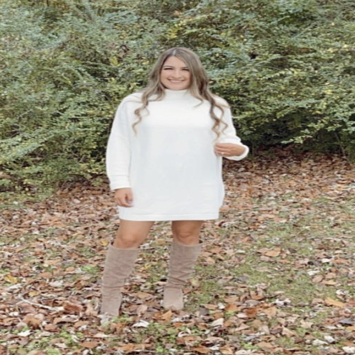 A customer review photo of them wearing the dress in a lush field of greenery
