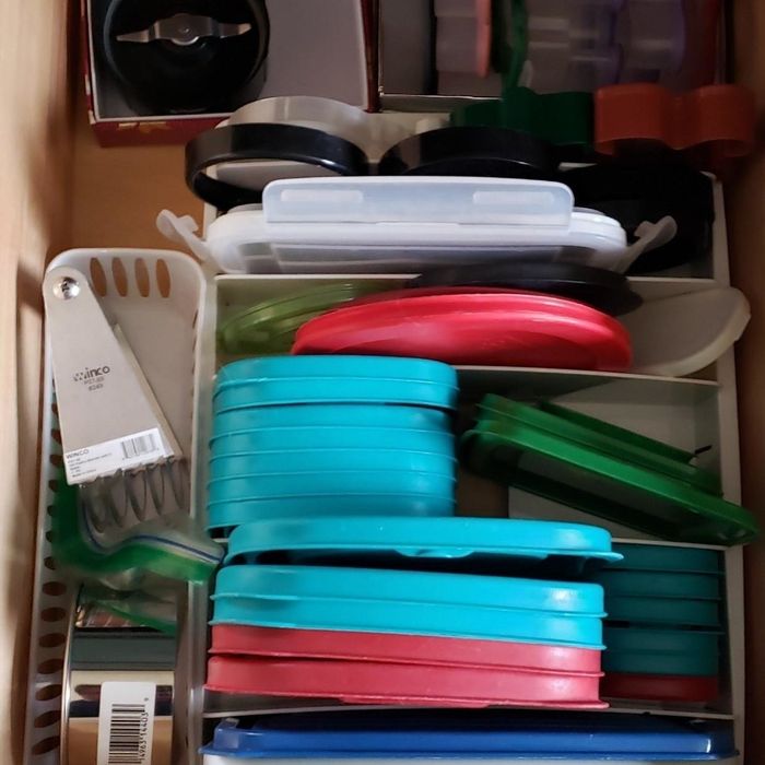 The same drawer with lids neatly stored in the organizer, bringing order to the chaos.