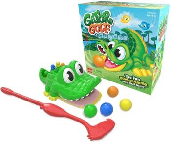 An alligator's mouth, a golf club, and golf balls positioned next to their packaging, ready for action.
