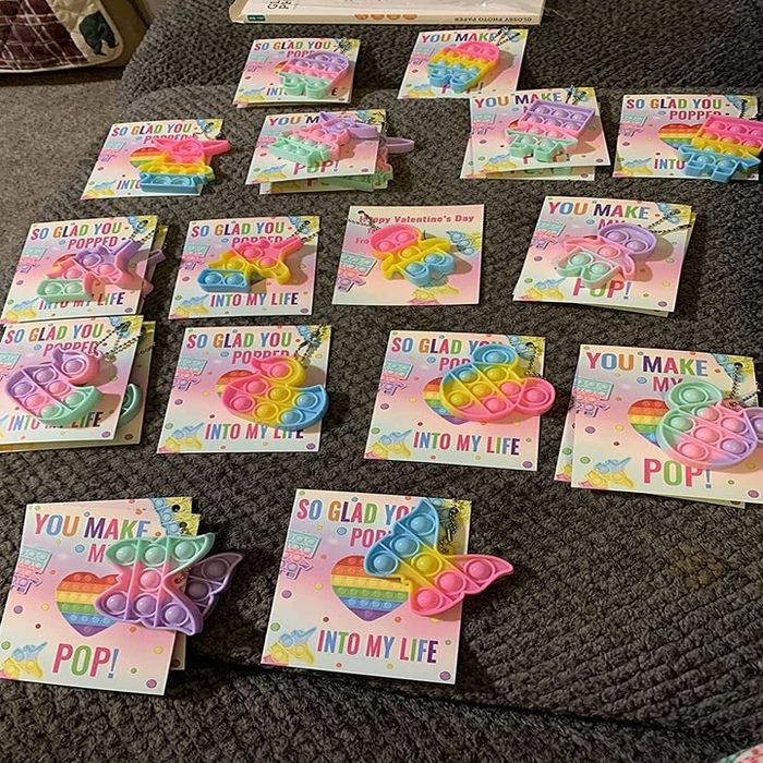 A photo from a reviewer showcasing a variety of pop-it toys and accompanying cards.