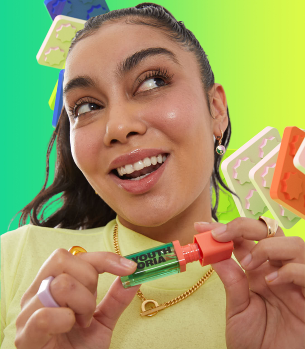 a model wearing the blush and holding the product tube