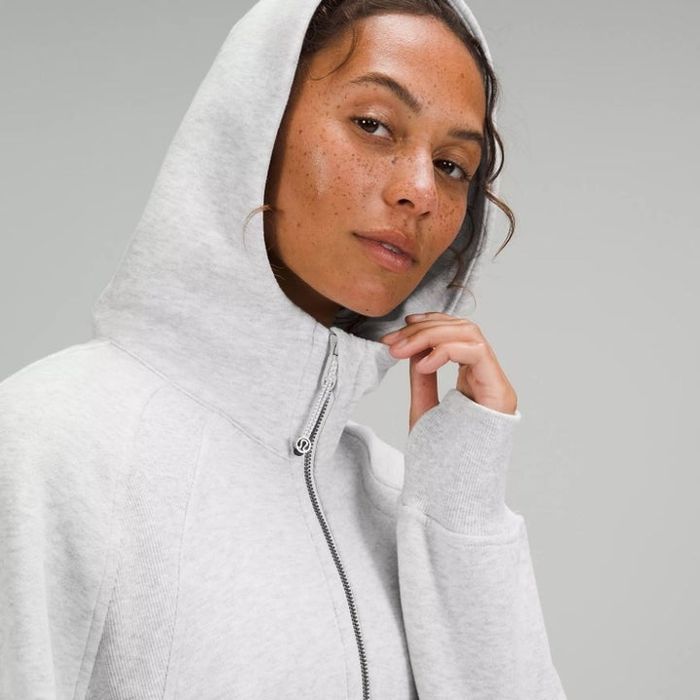 A model wearing an oversized half-zip hoodie in light grey with a hood.