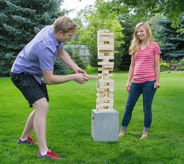 Two people engaged in a fun match of the wood stacking game.