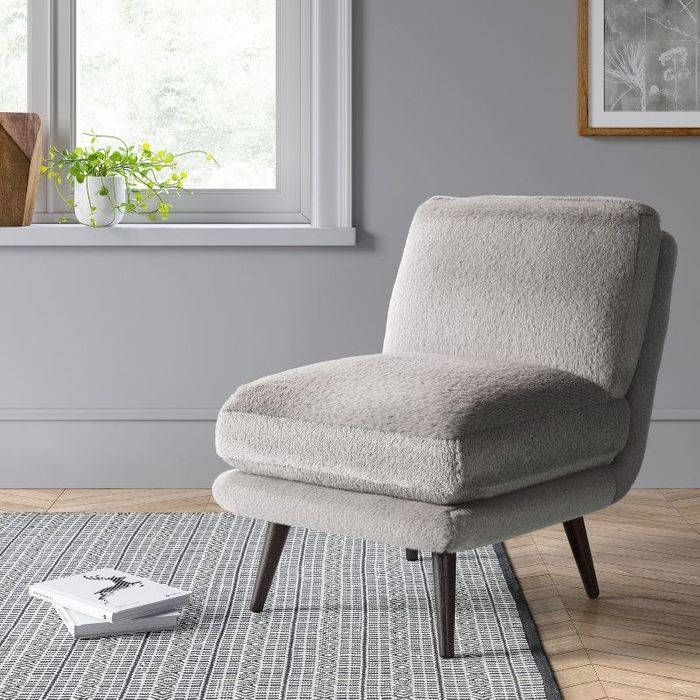 An image of a faux fur slipper chair with a hardwood frame.