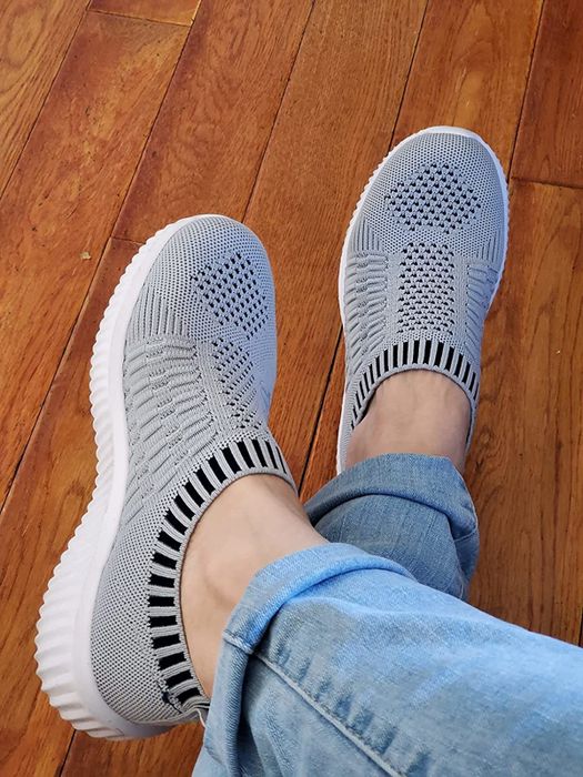 reviewer wearing the grey knit sneakers
