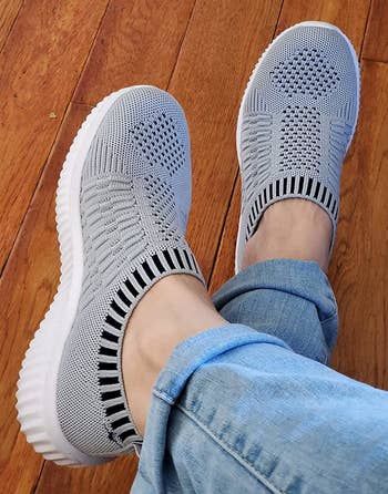 reviewer wearing the grey knit sneakers