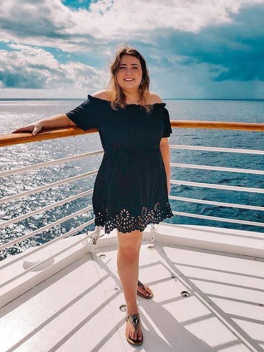 A reviewer is wearing a beige scalloped trim dress.