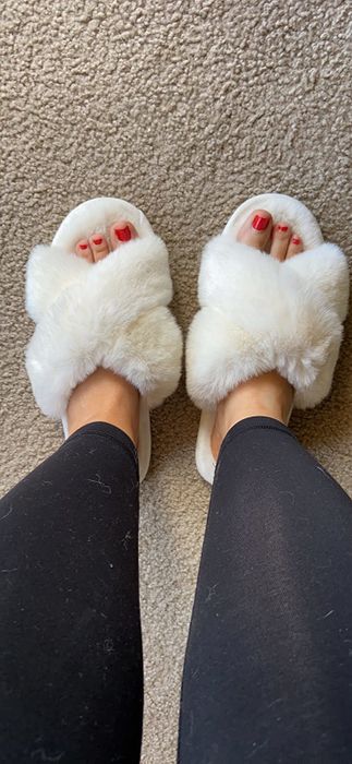 reviewer wearing the white fuzzy slippers