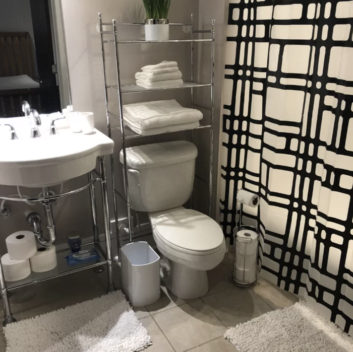 An over-the-toilet storage rack in silver above a toilet, perfect for maximizing space and adding style.