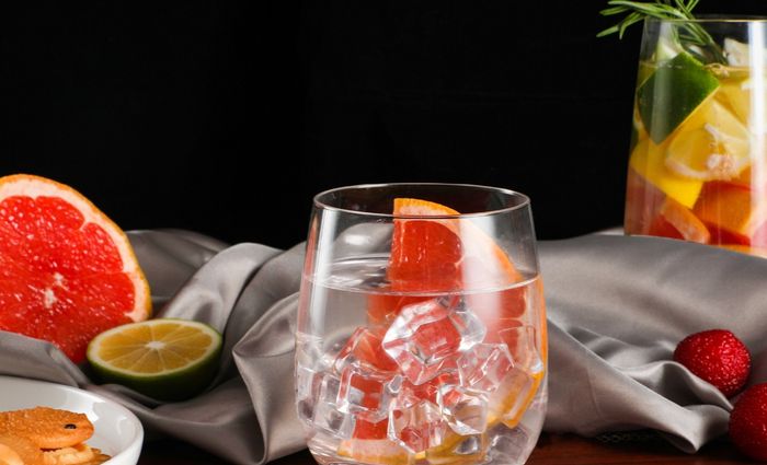 a glass filled with ice water and garnished with a slice of grapefruit