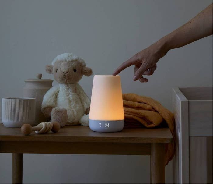 A glowing sound machine being touched by a hand