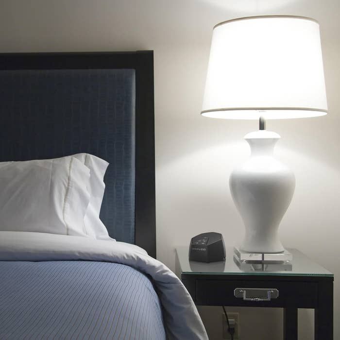 A sound machine placed on a bedside table