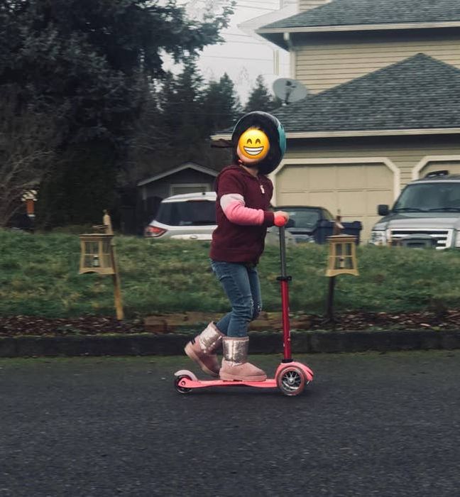 A reviewer's child enjoying a ride on the pink scooter.