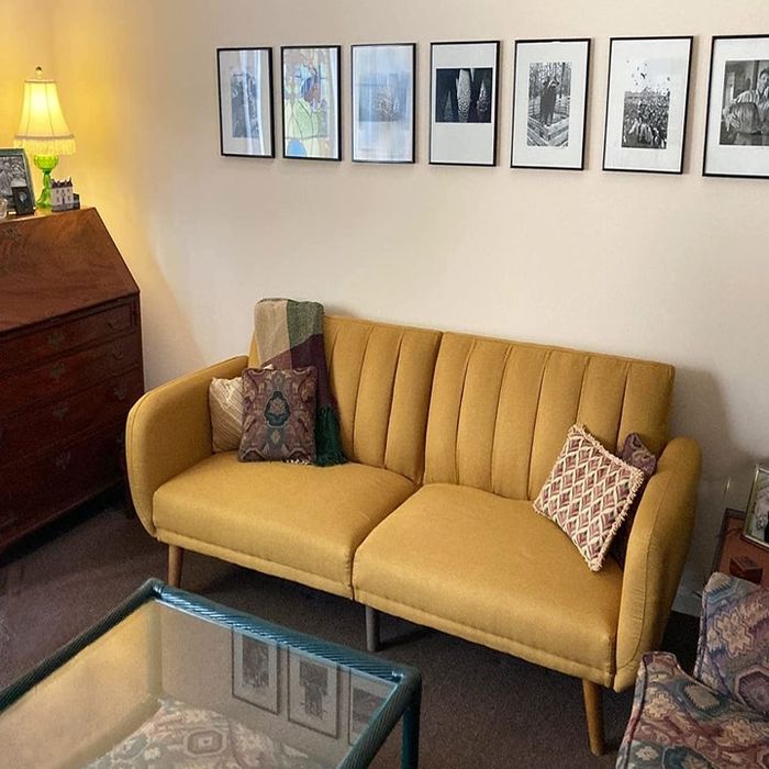 A reviewer’s photo of the mustard yellow futon in a stylish setting