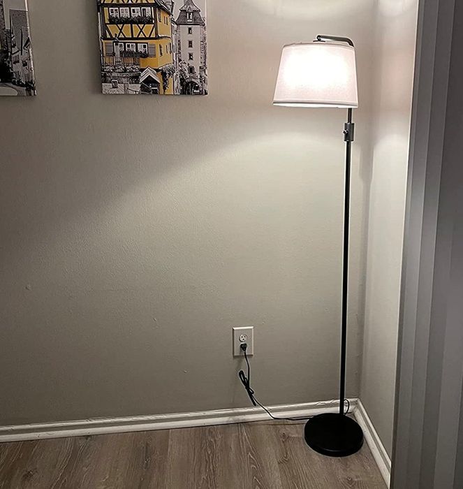 A reviewer’s photo of the floor lamp in a cozy living room setting