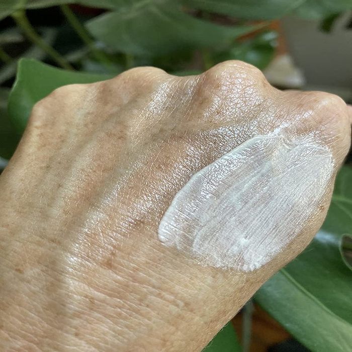 A reviewer applying the product to their hand.