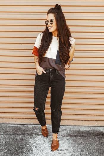 A reviewer showcasing the mules in a rich brown shade