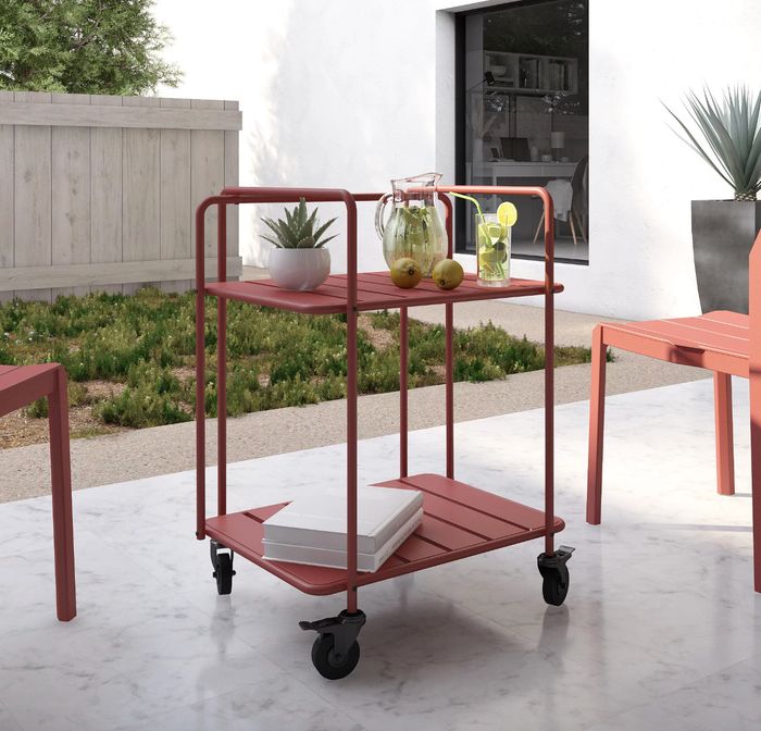 the red steel cart filled with drinks and decorative items in a charming outdoor setting