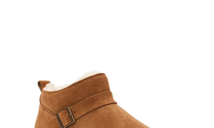 The boots in tan, featuring white wool lining and a stylish side buckle detail
