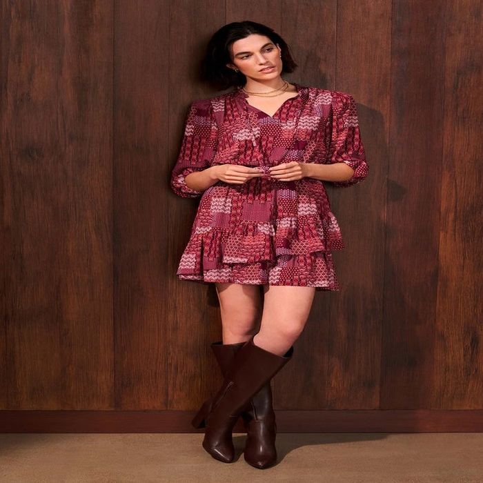 A model wearing the burgundy boots styled with a mini dress