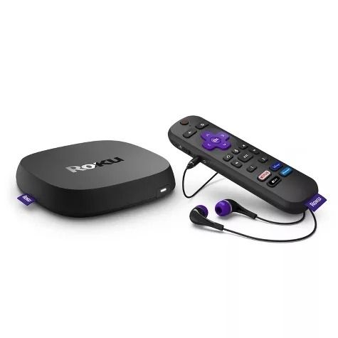 A Roku streaming device placed beside its remote control and headphones, perfect for private listening