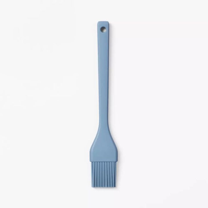 A silicone basting brush with a long handle and flexible bristles, designed for both cooking and baking.