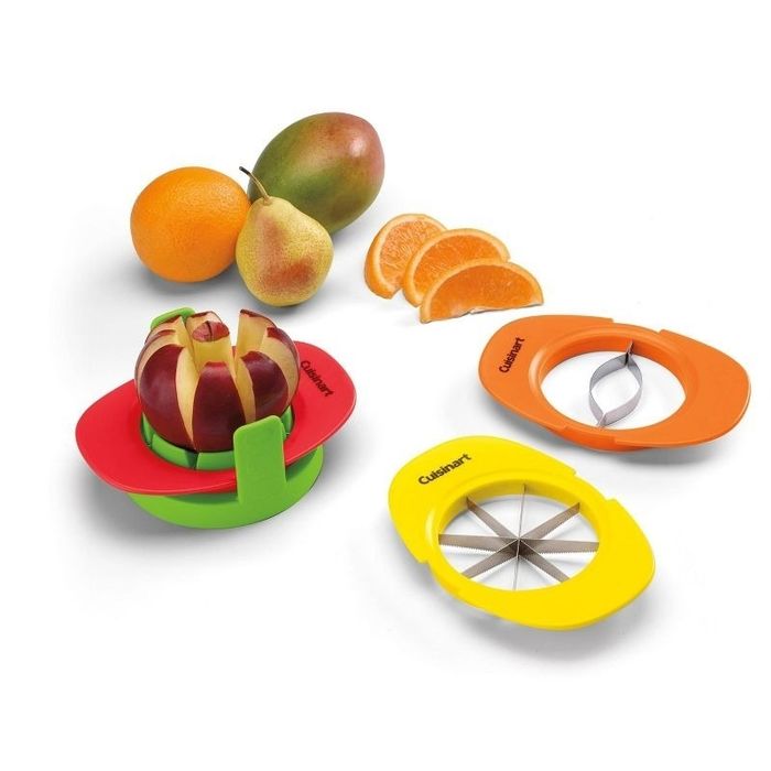 A Cuisinart fruit slicer and corer set displayed alongside a sliced apple, pear, mango, and oranges. Two slicers with different blade designs are shown