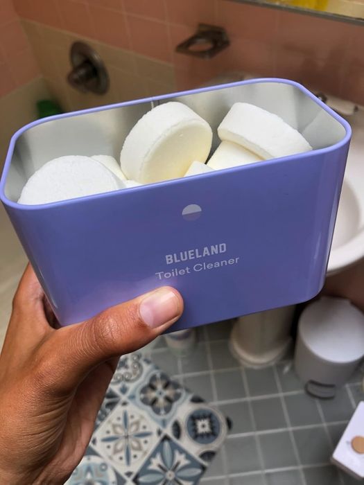 A hand holding a container labeled