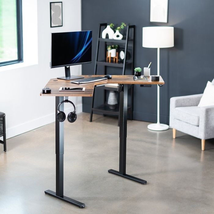 a contemporary standing desk setup with a monitor, keyboard, and headphones, set in a chic home office with shelves, a lamp, and an armchair in the background