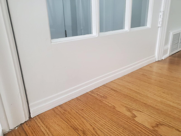A door with a white draft stopper securely in place at the bottom