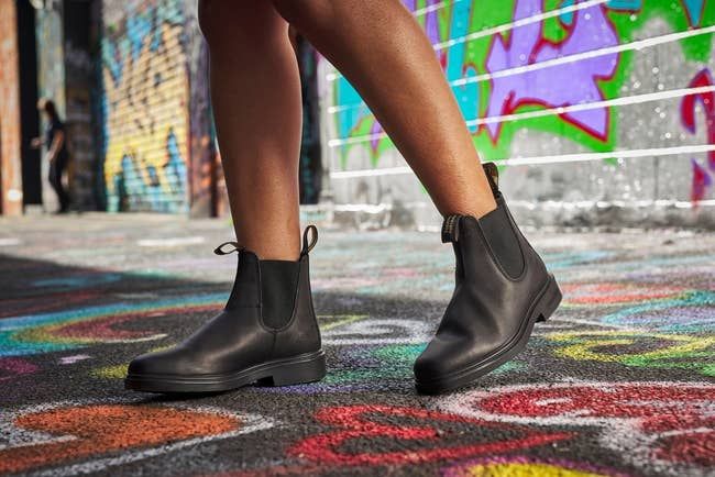 A detailed close-up of black leather ankle boots showcasing pull tabs