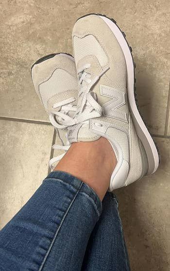 a reviewer wearing the shoes in a combination of white and tan