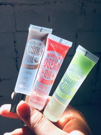 A reviewer showcasing three gloss tubes
