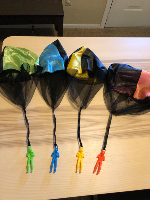 A reviewer's photo displaying the four parachute toys.