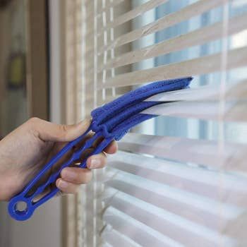 A blue duster specifically designed for cleaning blinds.