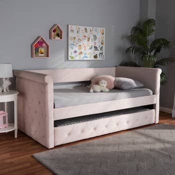 A pink velvet trundle bed placed in a little girl's room, adding a touch of whimsy and comfort.