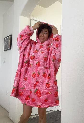 A reviewer standing in the sweater, showing it reaches all the way down to knee length.