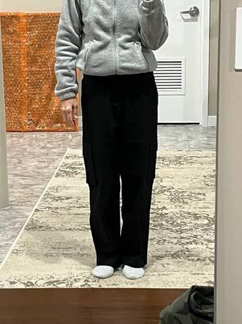 reviewer taking a mirror selfie while wearing black cargo pants