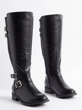 Tall black leather boots with two silver buckles, ideal for a shopping spree.
