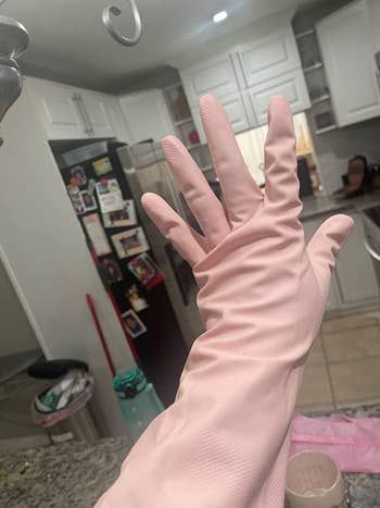 A reviewer wearing soft pink rubber gloves.