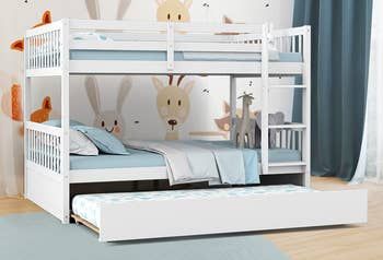 A lifestyle photo showcasing a white bunk bed with a trundle underneath.