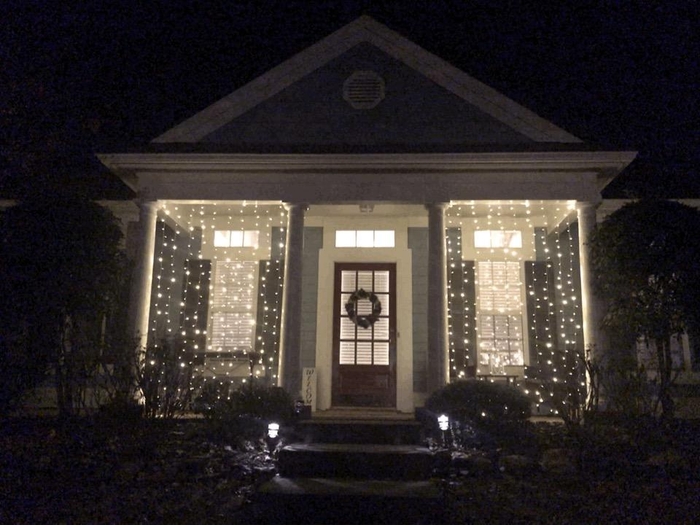 A reviewer photo showing two illuminated string light panels hanging between columns on their front porch
