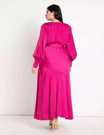 A model is shown from the back, wearing a hot pink satin maxi dress.