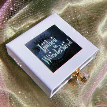 the lashes elegantly displayed in a delicate white box with a jeweled handle